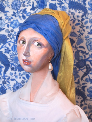 Girl Pearl Earring muse against blue Danube fabric. Made by Marina Elphick. Marina creates soft sculpted muses of the women in popular artists' lives and gives us an alternative narrative to their story. Marina's muses aim to educate and inform, appealing aesthetically to art lovers and students.